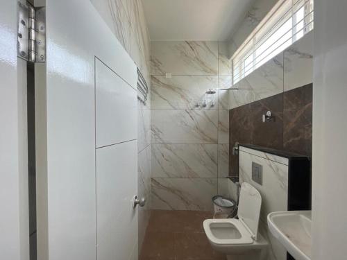 La salle de bains est pourvue de toilettes et d'un lavabo. dans l'établissement Seema Palace Inn, à Mysore