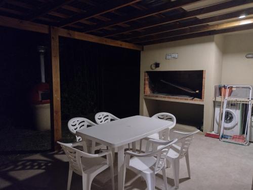 a white table and chairs in a room with a tv at BAHIA SAN FRANCISCO, casa Gaviotas, a 80 metros del mar, Uruguay in Piriápolis
