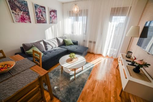 a living room with a blue couch and a table at 4Rest & 4Joy in Zlatibor
