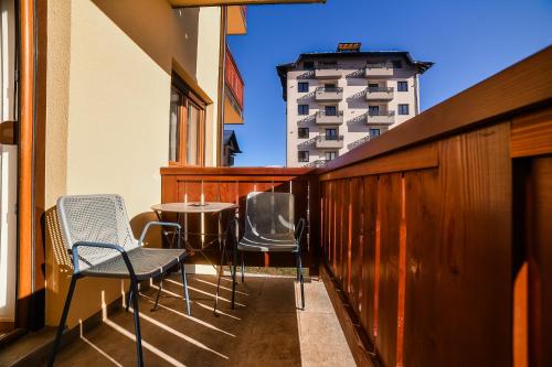 a balcony with chairs and a table and a building at 4Rest & 4Joy in Zlatibor