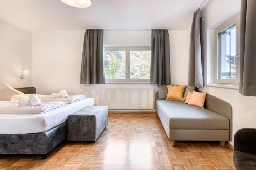 een slaapkamer met een bed en een bank bij FeWo mit 3 Schlafzimmern und Balkon - Galgenul in Galgenul