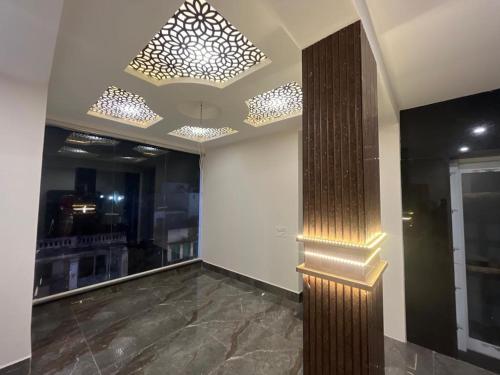 a lobby with a chandelier and a wall at Seema Palace Inn 1 km from Railwaystaion in Mysore
