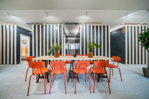 uma sala de jantar com uma mesa e cadeiras laranja em CUBES by Tegetthoff em Viena