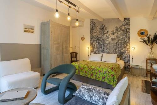 une chambre avec un lit, un canapé et une chaise dans l'établissement Mas la Pauline Gîtes de charme & roulotte, à Saint-Rémy-de-Provence