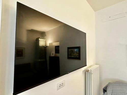 una grande TV a schermo piatto sul muro di una camera da letto di Townhouse Bozen a Bolzano