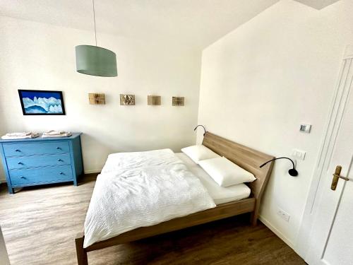 una camera da letto con un letto e un comò blu di Townhouse Bozen a Bolzano
