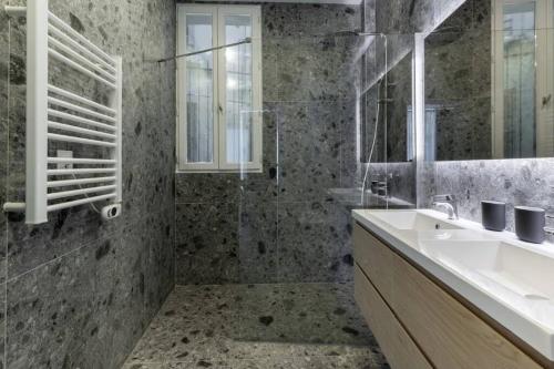 La salle de bains est pourvue d'un lavabo et d'une douche. dans l'établissement Stockholm/St-Lazare, à Paris