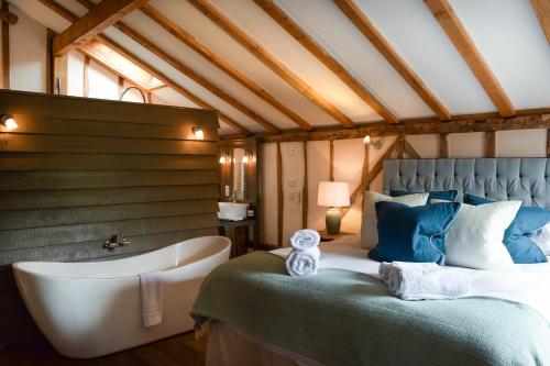 a bedroom with a large bed and a bath tub at Retreat East in Ipswich