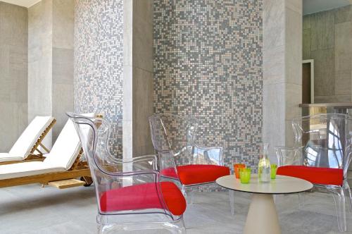 a room with chairs and a table and a wall at Domaine du Ferret Restaurant & Spa in Cap-Ferret