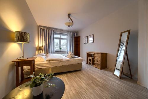 ein Hotelzimmer mit einem Bett und einem Spiegel in der Unterkunft Park Szczytnicki Cosy Apartment in Breslau