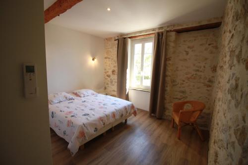 ein Schlafzimmer mit einem Bett, einem Fenster und einem Stuhl in der Unterkunft La Casa d'Anthony in Ginestas