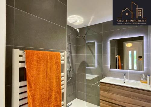 ein Badezimmer mit einem orangenen Handtuch und einer Dusche in der Unterkunft Belle villa vue sur montagnes in Châteauneuf