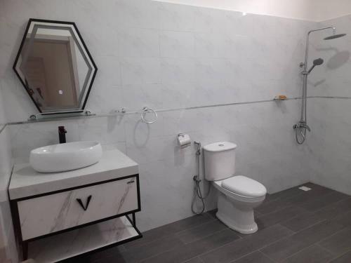 ein Badezimmer mit einem WC, einem Waschbecken und einem Spiegel in der Unterkunft Marijo Palace in Ndangane