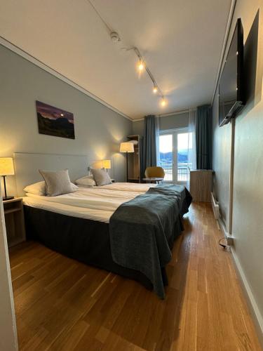 a bedroom with a large bed and a television at Brakanes Hotel in Ulvik