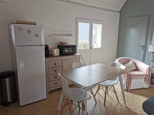 eine Küche mit einem Tisch und einem weißen Kühlschrank in der Unterkunft The place to be in Barneville-Carteret