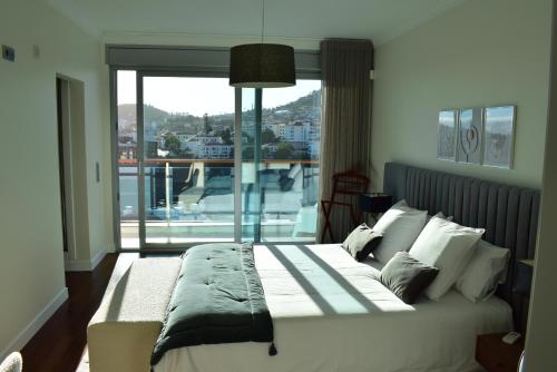 um quarto com uma cama e uma janela grande em Moradia Vista Atlântico em Funchal