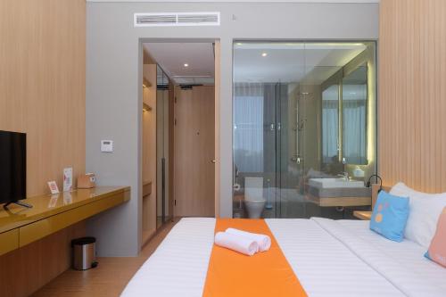 a hotel room with a bed and a bathroom at Sans Hotel RG Living Jogja by RedDoorz in Demangan