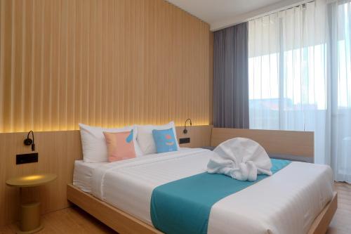 a bedroom with a large bed with blue and white pillows at Sans Hotel RG Living Jogja by RedDoorz in Demangan