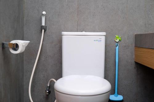 a bathroom with a white toilet and a shower at Sans Hotel RG Living Jogja by RedDoorz in Demangan