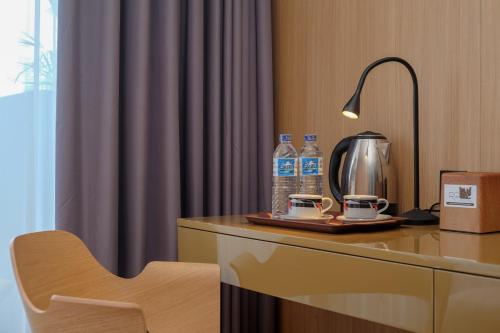 a hotel room with a table with drinks and a lamp at Sans Hotel RG Living Jogja by RedDoorz in Demangan
