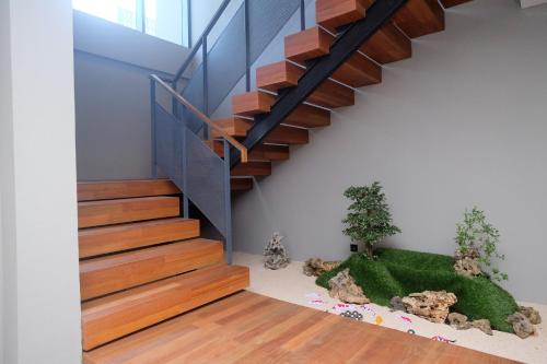a staircase in a house with a plant at Sans Hotel RG Living Jogja by RedDoorz in Demangan