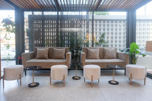 a lobby with two couches and chairs and tables at Sans Hotel RG Living Jogja by RedDoorz in Demangan