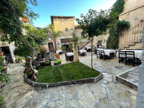 a courtyard with a garden with a fountain and tables at Sofa Hotel in Avanos
