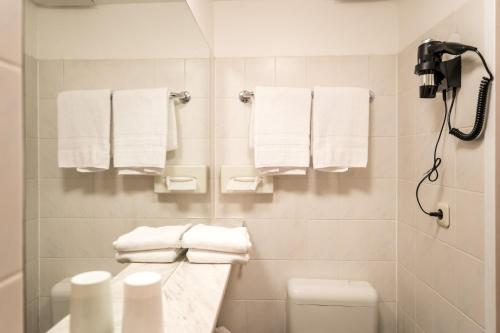 a white bathroom with towels hanging on the wall at Antares Apartments in Düsseldorf