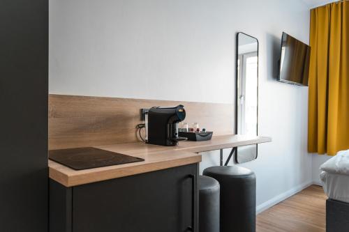 een koffiezetapparaat op een aanrecht in een kamer bij Antares Apartments in Düsseldorf
