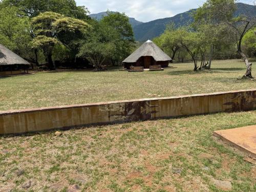 een veld met een hut op de achtergrond bij Zambalile@Blouberg Camp in Blouberg