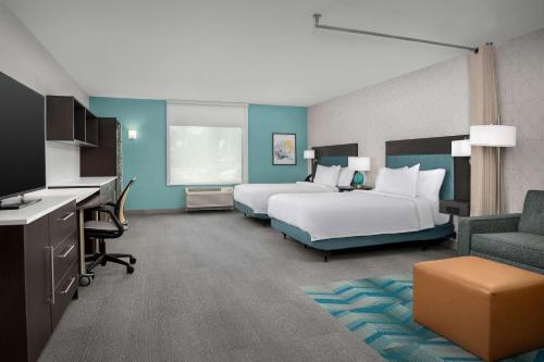 ein Hotelzimmer mit 2 Betten und einem Flachbild-TV in der Unterkunft Home2 Suites Orlando Southeast Nona in Orlando