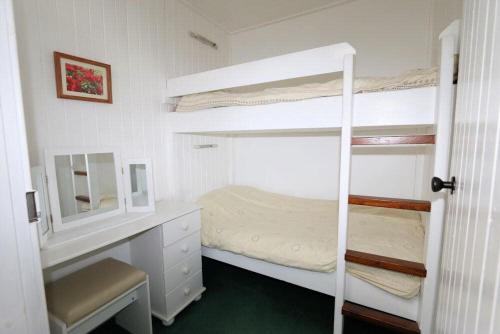 Ellary Cottage في Stonefield: غرفة نوم مع سريرين بطابقين ومكتب