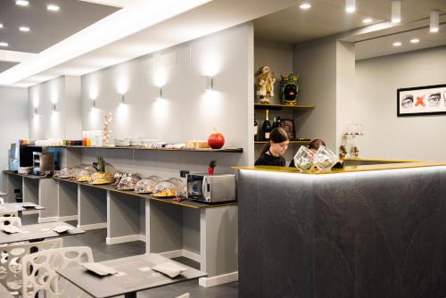a woman standing at a counter in a restaurant at Alma Hotel in Palermo