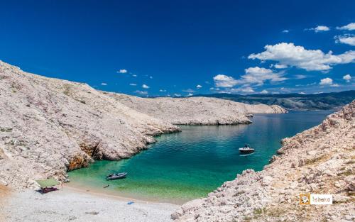 two boats in a body of water between two rocks at Villa Valis in Baška