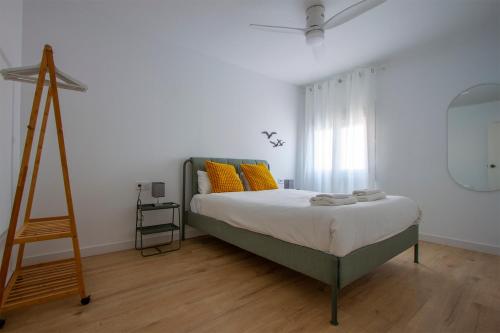 una camera da letto con un letto con cuscini gialli e una scala di Feel Welcome Barcelona # SPLAU a Cornellà de Llobregat