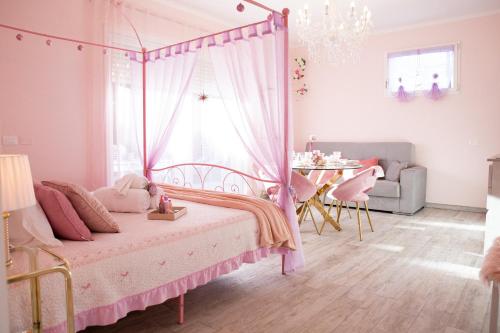 a pink bedroom with a bed with a canopy at Villetta Tinmar Barbie House Verona in Verona