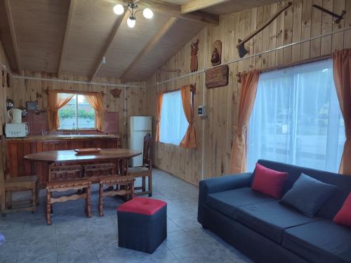 uma sala de estar com um sofá e uma mesa em cabaña zoila em Coñaripe