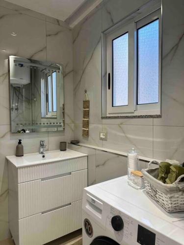 bagno con lavandino e lavatrice di Sunshine Apartment Tirana, Sheshi Wilson a Tirana