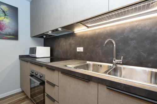 a kitchen with a sink and a microwave at The Captain Apartment Sirmione in Sirmione