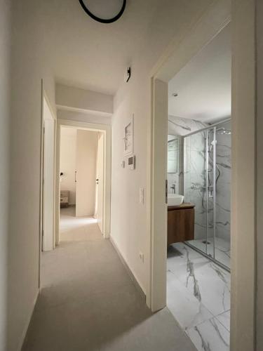 - un couloir d'une salle de bains pourvue d'un lavabo et d'un miroir dans l'établissement Gleaming apartments near Athens Metro Mall, à Athènes