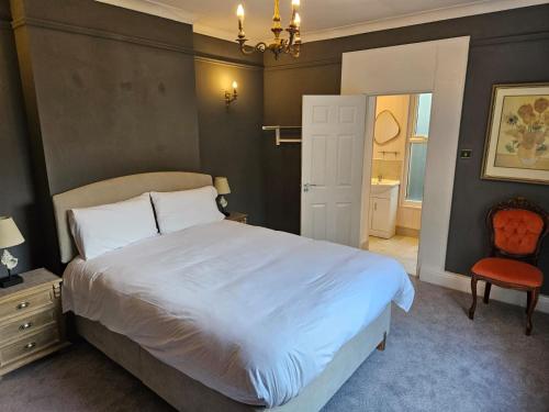 sypialnia z dużym białym łóżkiem i krzesłem w obiekcie Boutique Guest House w Galway