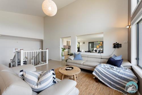 Elle comprend un salon doté d'un mobilier blanc et d'oreillers bleus. dans l'établissement Bass point shell Cove holiday home, à Dunmore