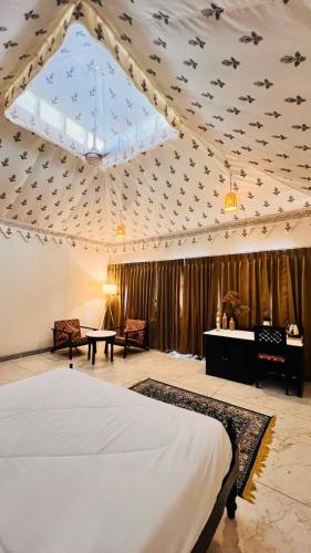 a bedroom with a bed and a ceiling with birds on it at Jawai Greens in Jawāi Bāndh