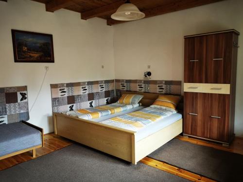 una camera con letto e armadio in legno di Rebeka Vendégház a Erdőhorváti
