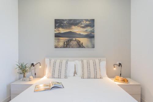 - une chambre avec un lit blanc et un livre dans l'établissement Isola Felice Grandate by Rent All Como, à Côme
