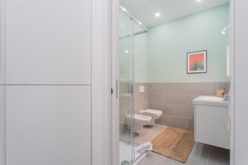La salle de bains est pourvue de toilettes et d'une douche en verre. dans l'établissement Isola Felice Grandate by Rent All Como, à Côme