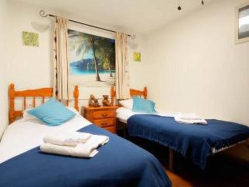 a bedroom with two beds with blue sheets and a window at Apartment in Soo in Soo