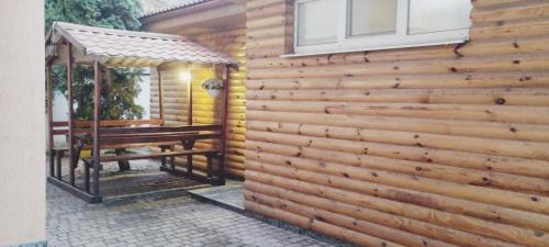 a wooden fence with a bench and a gazebo at Domino in Berehove