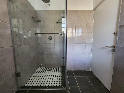 a bathroom with a shower with a glass door at Tenbury by the beachfront 806 in Durban