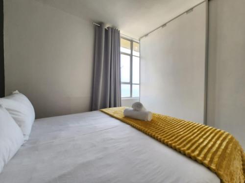 a bedroom with a bed with a yellow blanket on it at Tenbury by the beachfront 806 in Durban